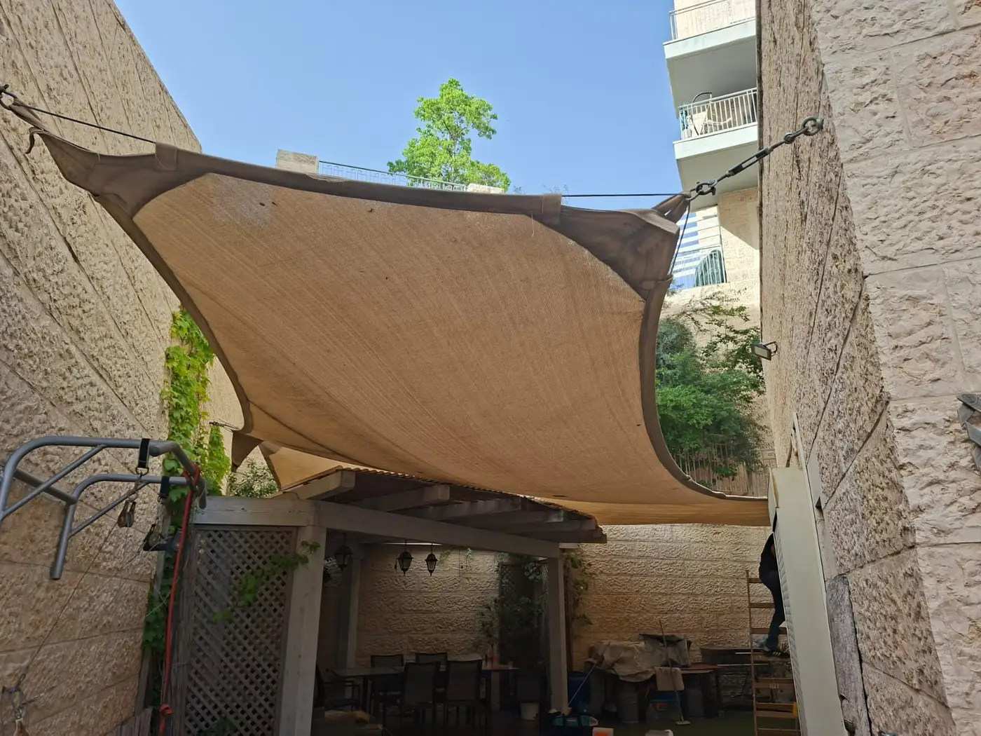 מפרש הצללה מעל פינת ישיבה בחצר